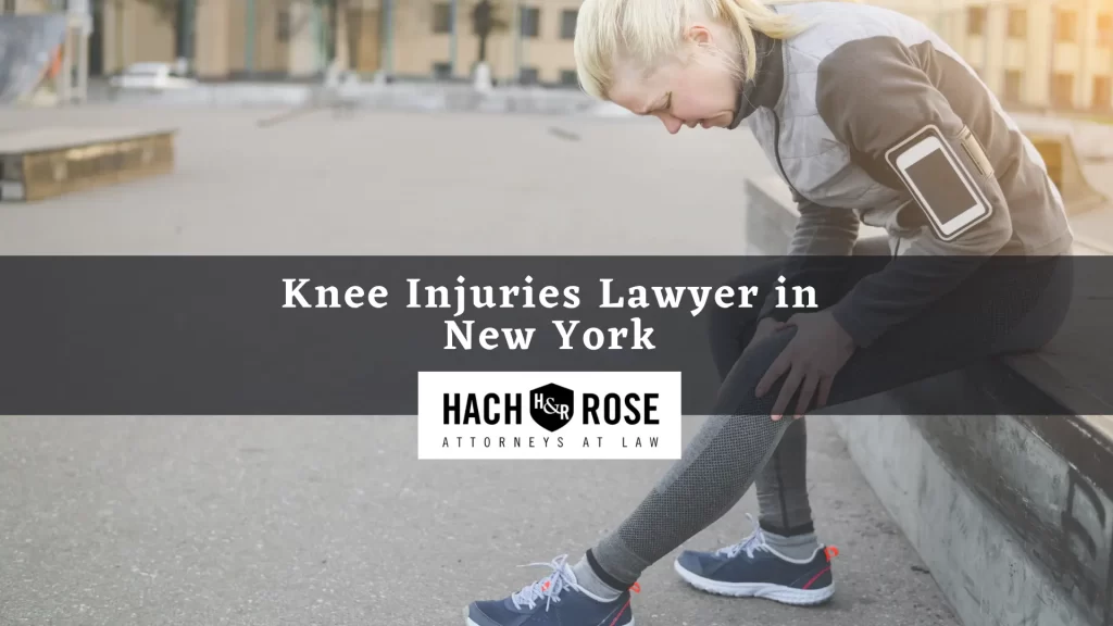 Woman jogger sits and hold her knee in an urban setting, showing the need for a New York knee injury lawyer.